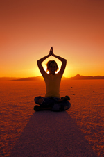 mujer meditando al atardecer